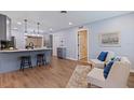 Open-concept kitchen and living area featuring an island with bar seating and modern pendant lighting at 5690 82Nd N Ter, Pinellas Park, FL 33781