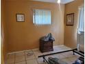 Empty bedroom featuring tan walls, tiled floor, bright window and space for furniture at 6818 59Th St, N., Pinellas Park, FL 33781
