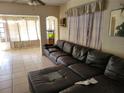 Cozy living room featuring tile flooring, a large leather sectional sofa, and bright natural light at 6818 59Th St, N., Pinellas Park, FL 33781