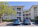 Exterior view of condo building featuring balconies, assigned parking, and beautiful landscaping at 6826 Stones Throw N Cir # 11308, St Petersburg, FL 33710