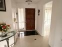Inviting foyer with ceramic tile flooring, chandelier, and access to other rooms at 7031 Drury St, Tampa, FL 33635