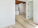 Inviting hallway with light wood floors and freshly painted white walls at 9445 Cardy St, New Port Richey, FL 34654