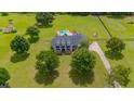 Aerial shot of a two-story home featuring a large lawn, mature trees, and a long driveway leading to the house at 10510 Lithia Estates Dr, Lithia, FL 33547