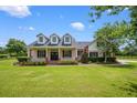 Charming home with a large front porch, dormer windows, and a well-manicured lawn at 10510 Lithia Estates Dr, Lithia, FL 33547