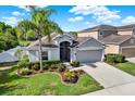 Lovely single-story home with manicured landscaping, lush green lawn and a view of the nearby pond at 11309 Langworth Hill Ln, Riverview, FL 33579