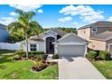 Beautiful single-story home with well-manicured lawn, flowering plants and two car garage on a sunny day at 11309 Langworth Hill Ln, Riverview, FL 33579