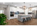 Bright kitchen with white cabinets, stainless steel appliances, a wooden-style island, and modern pendant lights at 11714 Tetrafin Dr, Riverview, FL 33579