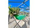 Relaxing screened-in pool area featuring lush tropical foliage and a serene view of the water at 12603 Midpointe, Riverview, FL 33578
