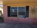 Exterior view of a home with black shutters and window with a decorative metal design at 13710 Frances Ave, Hudson, FL 34667