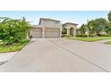 Spacious home with a large driveway leading to an attached three-car garage and well-maintained landscaping at 1553 Canopy Oaks Blvd, Palm Harbor, FL 34683