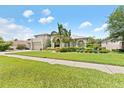 Charming two-story home with a lush, landscaped front yard and a symmetrical design at 1553 Canopy Oaks Blvd, Palm Harbor, FL 34683