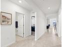 Bright hallway with tile floors connecting to a bathroom, office, and living spaces at 15825 Mauvewood Ave, Odessa, FL 33556