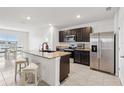 Modern kitchen with stainless steel appliances, granite countertops, and a convenient island at 15825 Mauvewood Ave, Odessa, FL 33556
