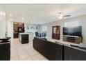 Open concept living room, dining area, and kitchen with tile flooring and a ceiling fan at 17156 Yellow Pine St, Wimauma, FL 33598