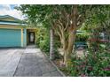 Inviting home with a walkway leading to the entrance, surrounded by mature trees and greenery at 17807 Fallowfield Dr, Lutz, FL 33549