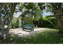 Secluded front yard featuring a garden bench and mature trees offering plenty of shade at 17807 Fallowfield Dr, Lutz, FL 33549