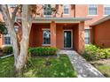 Inviting front entrance with a well-kept lawn, shrubbery, and tree providing shade and curb appeal at 2066 Sun Down Dr, Clearwater, FL 33763