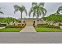 Well-maintained single-story home with a two-car garage, complemented by neatly trimmed hedges and colorful flowers at 2292 Sifield Greens Way # 59, Sun City Center, FL 33573