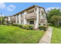 Condo exterior featuring green grass and manicured landscaping at 2368 Flanders Way # D, Safety Harbor, FL 34695