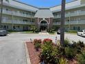 Exterior shot of a multi-story building featuring meticulous landscaping and ample parking at 2459 Columbia Dr # 39, Clearwater, FL 33763