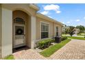 Charming home entrance featuring a decorative wreath, arched doorway, and beautiful brick walkway at 2537 Stanhope Dr, New Port Richey, FL 34655