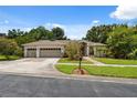 Charming single-story home with a three-car garage, manicured lawn, and mature landscaping at 3037 Crest Dr, Clearwater, FL 33759