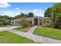 Inviting single-story home with a two-car garage and a meticulously maintained front yard at 3037 Crest Dr, Clearwater, FL 33759
