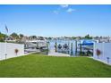 Waterfront property featuring a private boat dock with multiple boat slips and jet ski lifts on a sunny day at 311 22Nd St, Belleair Beach, FL 33786