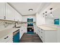 Modern kitchen with white cabinetry, marble backsplash, and blue appliances at 3614 Vasco St, Punta Gorda, FL 33950