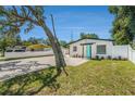 A nicely maintained white home with white rock landscaping and a bright teal door at 3617 E Louisiana Ave, Tampa, FL 33610