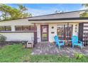 Charming home with two light blue chairs outside the front door and black trimmed windows at 489 W Davis Blvd, Tampa, FL 33606