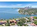 Waterfront home with bay views, palm trees, a brick patio, and lush landscaping at 501 Brightwaters Ne Blvd, St Petersburg, FL 33704