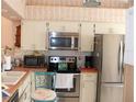 Bright kitchen featuring stainless steel appliances and white cabinets at 5581 Greyston St, Palm Harbor, FL 34685