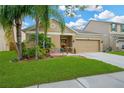 Beautiful home with lush green lawn, palm trees and an attached two-car garage at 5806 Tulip Flower Dr, Riverview, FL 33578