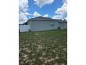 View of the back of the home and backyard area with a white vinyl fence at 7056 Landover Blvd, Spring Hill, FL 34608