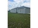 View of the side of the single Gathering home with access door and attached garage at 7056 Landover Blvd, Spring Hill, FL 34608