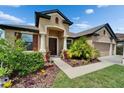 Inviting home exterior showcases a beautifully landscaped front yard with mature tropical plants and mulch at 11911 Sunburst Marble Rd, Riverview, FL 33579