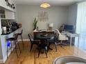 Open dining area with modern black table and chairs and hardwood floors at 1301 S Howard Ave # C4, Tampa, FL 33606