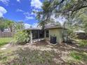 The backyard shows mature trees and partial view of the screened in porch at 1319 Dew Bloom Rd, Valrico, FL 33594