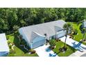 An aerial view showcases the home with its well-maintained roof, landscaping, and expansive driveway at 2019 Gardenia Landings Lane Ln, Sun City Center, FL 33573