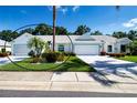 Charming single-story home featuring a two-car garage, lush landscaping, and a well-manicured lawn at 2019 Gardenia Landings Lane Ln, Sun City Center, FL 33573