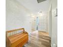 Welcoming entryway featuring wood-look flooring, a charming wood bench, and natural light at 22422 Stillwood Dr, Land O Lakes, FL 34639