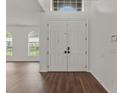 Bright foyer with white double doors, hardwood floors, and ample natural light from the arched windows at 2812 Windcrest Oaks Ct, Valrico, FL 33594