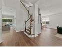 Welcoming foyer showcases hardwood floors, a staircase with wood and white railings, and open-concept living spaces at 2812 Windcrest Oaks Ct, Valrico, FL 33594