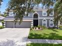Beautiful two-story home showcasing a lush front yard and a spacious three-car garage at 2812 Windcrest Oaks Ct, Valrico, FL 33594
