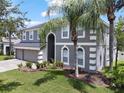 Elegant two-story home featuring a well-manicured lawn and a convenient three-car garage at 2812 Windcrest Oaks Ct, Valrico, FL 33594