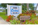 Caribay community sign surrounded by colorful flowers and lush greenery at 2980 Haines Bayshore Rd # 105, Clearwater, FL 33760