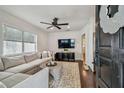Bright living room features hardwood floors, neutral sofa, ceiling fan, and a large window with natural light at 3127 W Oakellar Ave, Tampa, FL 33611