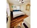 Cozy bedroom featuring a ceiling fan, wood floors, and natural light from the bright window at 3135 33Rd N Ave, St Petersburg, FL 33713