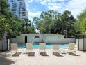 Community pool with multiple lounge chairs and umbrellas surrounded by lush tropical greenery at 3325 Bayshore Blvd # C14, Tampa, FL 33629